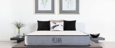 The Firm & Extra Firm flippable Plank mattress by Brooklyn Bedding laying on a platform bed with pillows in a master bedroom with artwork on the walls.