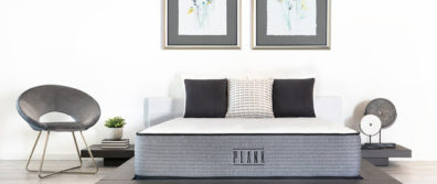 The Firm & Extra Firm flippable Plank Luxe Hybrid mattress by Brooklyn Bedding laying on a platform bed with pillows in a master bedroom with artwork on the walls.